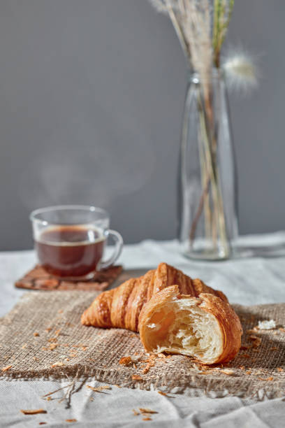 istock Morning breakfast still life with fresh croissants and coffee cup on a gray. 1154091214