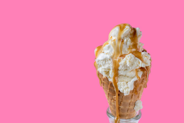 istock melting vanilla ice cream scoops with dripping caramel sauce over waffle cone on fun vibrant pink 1154093644