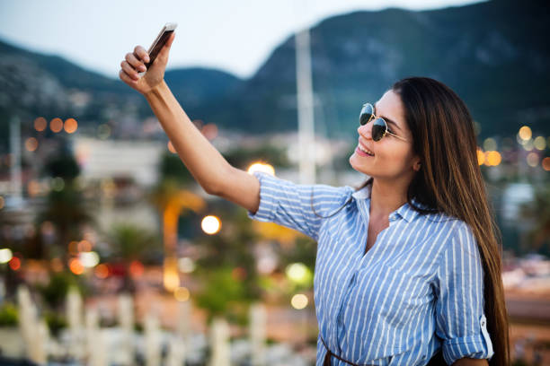 istock Happy young woman taking selfie on vacation 1154095703