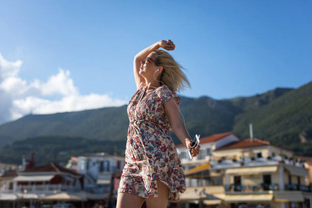 istock Happy young woman dancing during summer vacation 1154095882