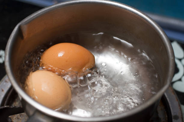 istock Two eggs in boiling water in stainless steel pan on the kitchen stove. 1154101476