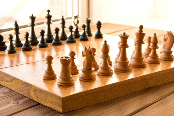 istock Chessboard with figures on a wooden table. Selective focus. 1154102282
