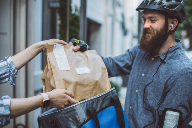 Food delivery Bicycle delivery commuter with road bicycle delivering package to customer bicycle basket stock pictures, royalty-free photos & images