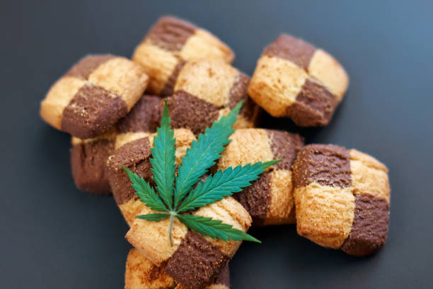 istock Hemp biscuits on a dark background with a green leaf of cannabis. Marijuana CBD dessert. Copy space. View from above 1154103926