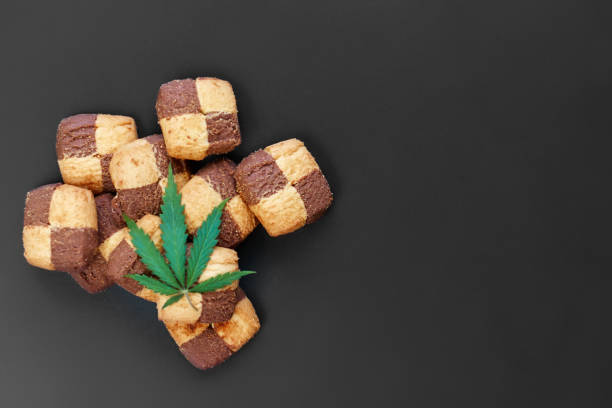 istock Hemp biscuits on a dark background with a green leaf of cannabis. Marijuana CBD dessert. Copy space. View from above 1154103936