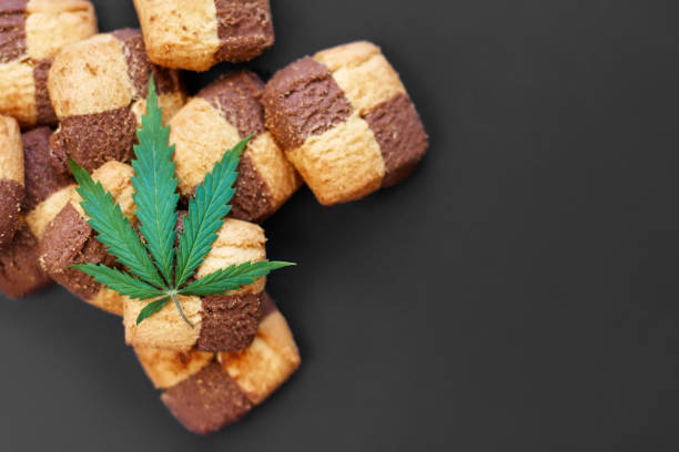 istock Hemp biscuits on a dark background with a green leaf of cannabis. Marijuana CBD dessert. Copy space. View from above 1154103954