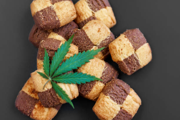 istock Hemp biscuits on a dark background with a green leaf of cannabis. Marijuana CBD dessert. Copy space. View from above 1154103962
