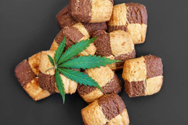 istock Hemp biscuits on a dark background with a green leaf of cannabis. Marijuana CBD dessert. Copy space. View from above 1154103964