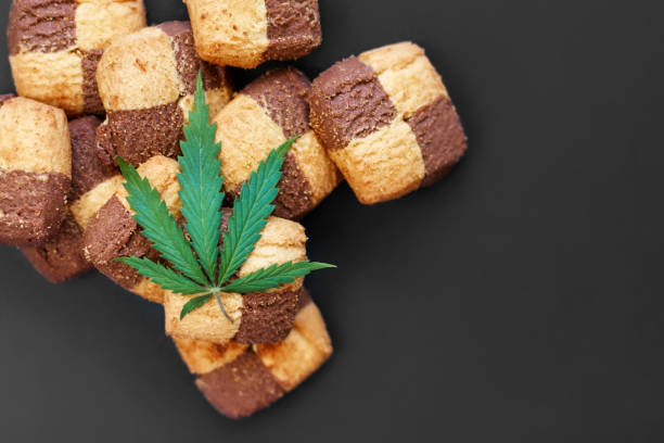 istock Hemp biscuits on a dark background with a green leaf of cannabis. Marijuana CBD dessert. Copy space. View from above 1154103967