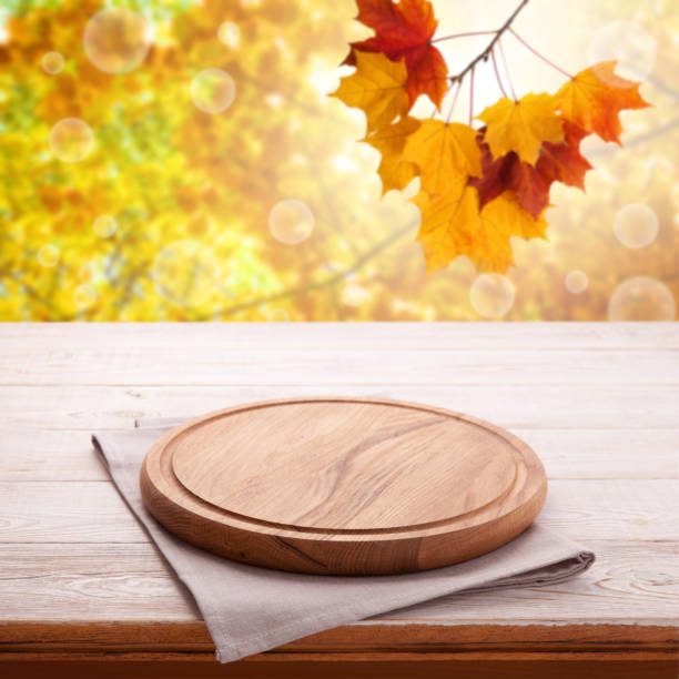 istock Wooden table with empty board for pizza and tablecloth. Autumn background top view mock up. Selective focus. 1154105102