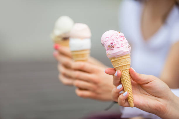 istock Delicious three ice cream in female hands - close-up. 1154105227