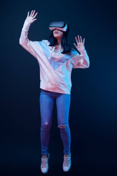 istock brunette young woman gesturing while wearing virtual reality headset on blue 1154112208