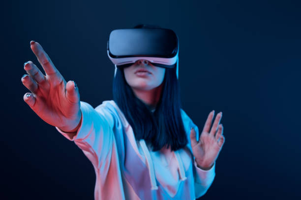 istock selective focus of young woman gesturing while using virtual reality headset on blue 1154112234