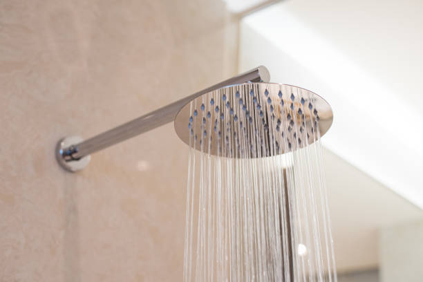 istock Shower turned on, overhead ceiling shower faucet head closeup. 1154113224
