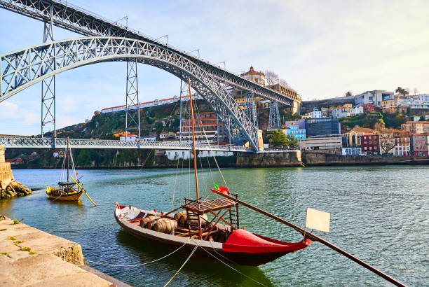 bateaux typiquement portugais en bois, appelés "barcos rabelos" transportant des tonneaux de vin sur le fleuve douro avec vue sur villa nova de gaia à porto, portugal - portugal port wine porto the douro photos et images de collection