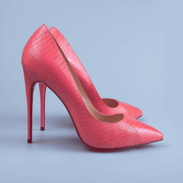 istock female pink shoes on blue background 1154117485