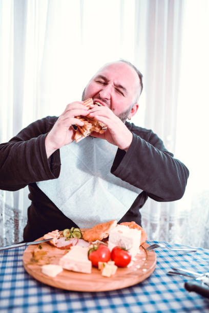 istock Hungry Male Chewing On Enormous Sandwich 1154117785