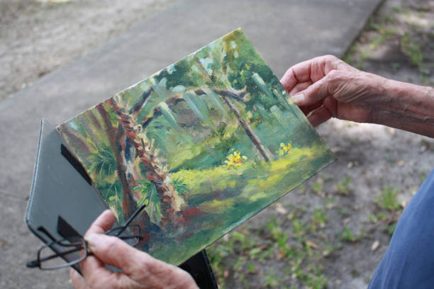 istock Watercolor painting held by Senior woman's hands 1154119013