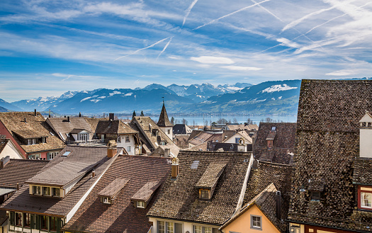 Roofs of the medieval old town of Rapperswil with the snow capped alpine ranges in the background, Sankt Gallen, Switzerland.