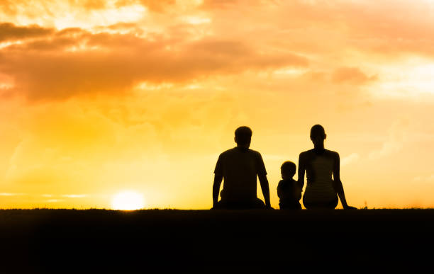 istock Happy family relaxing outdoors at sunset. 1154127000