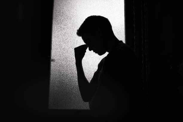 istock Tired young man in the dark room 1154127189