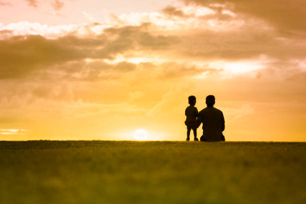 silhouette di padre e del suo bambino che guardano il tramonto. - travel the americas human age viewpoint foto e immagini stock