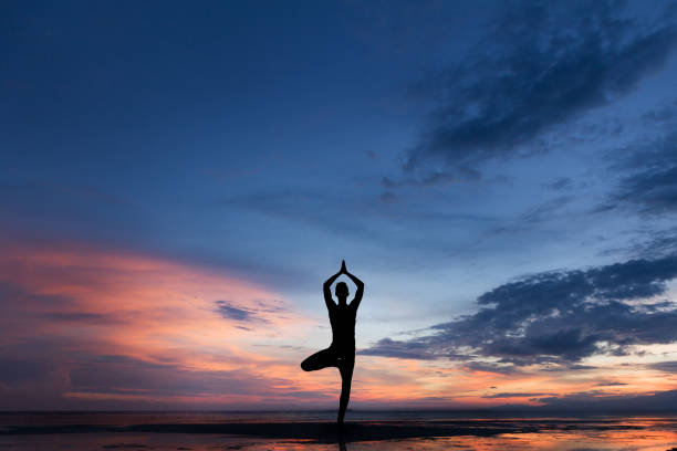 istock Silhouette photo of man practicing yoga at sunset 1154130978