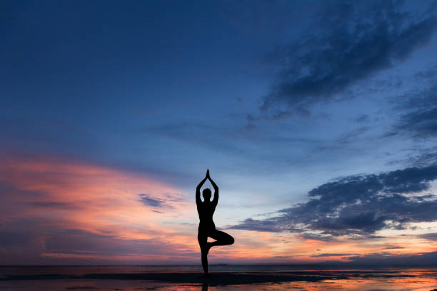 photo de silhouette de femme pratiquant le yoga au coucher du soleil - nirvana photos et images de collection