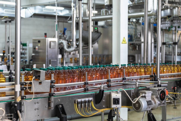 istock Plastic bottles with fresh organic juice on automatic conveyor belt or line in beverage factory or plant interior inside 1154136495