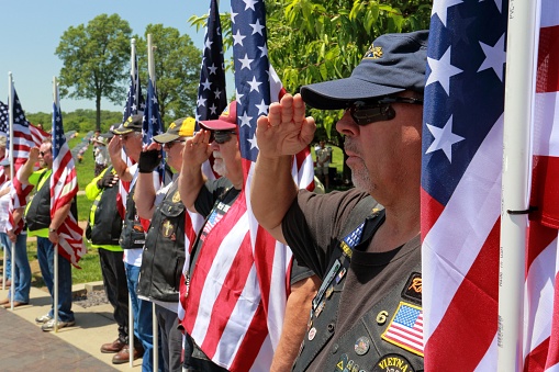 Springfield Missouri - May 27 2019 Veterans saluting during memorial day ceremony at veterans memorial cemetery.
