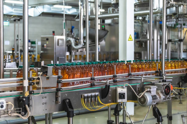 istock Plastic bottles with fresh organic juice on automatic conveyor belt or line in beverage factory or plant interior inside 1154136902