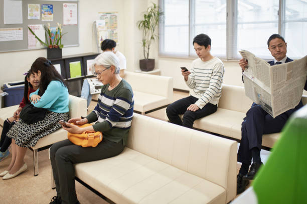 patients assis dans la salle d’attente d’hôpital - japan serious family senior adult photos et images de collection