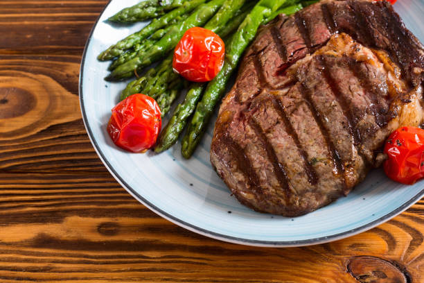 istock Grilled beef steak ribeye with cherry tomatoes and asparagus 1154139673