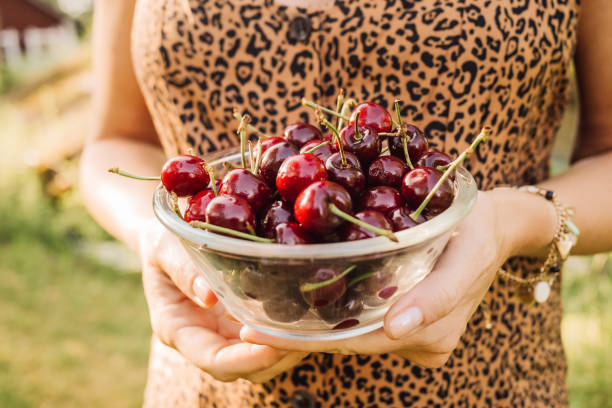 istock Woman Outdoors in summer eating cherry berries 1154140970