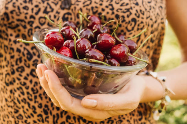 istock Woman Outdoors in summer eating cherry berries 1154141258