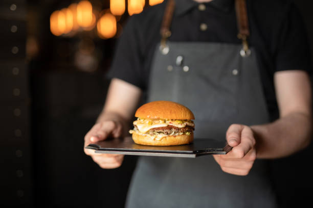 クライアントのためのハンバーガーを運ぶウェイター - 給仕する ストックフォトと画像
