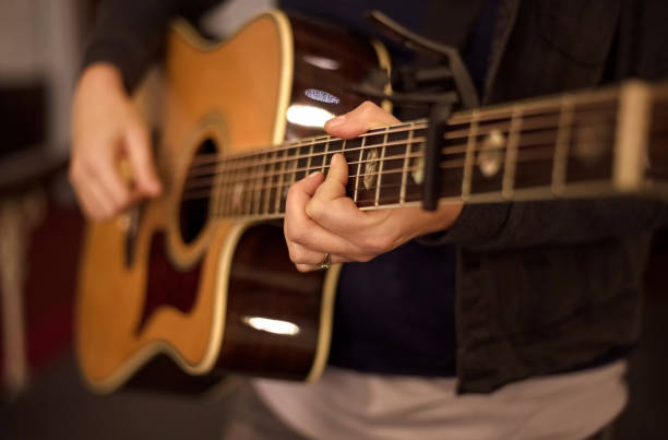 istock Guitar sings in her hands 1154146508