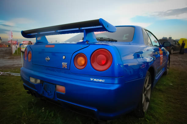 The blue color Nissan skyline GTR R34 stands on the grass stock photo