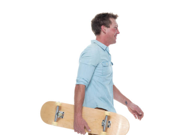 istock Casual well dressed man walking with a skateboard 1154162267