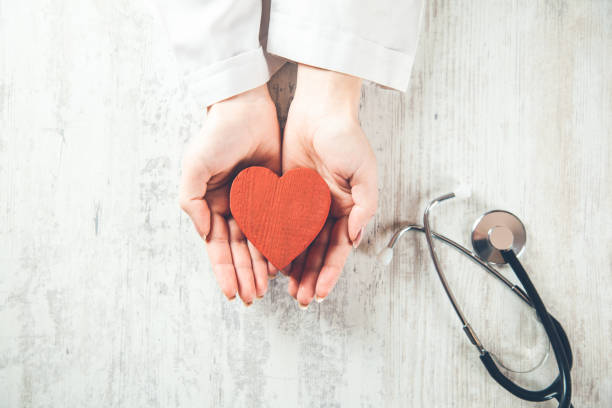 istock doctor hand heart and stethoscope on desk 1154166333
