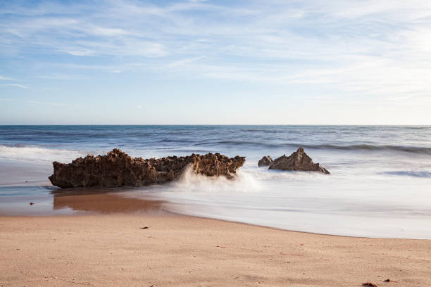 istock Rocks on the surf of the beach waves. 1154173455