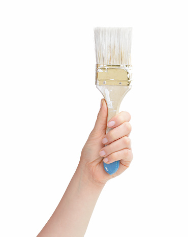 Man hand holding an old paintbrush ready to paint isolated on a white background