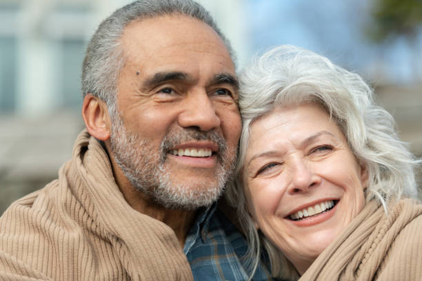 istock Senior couple wrapped in a blanket on a beach 1154221279