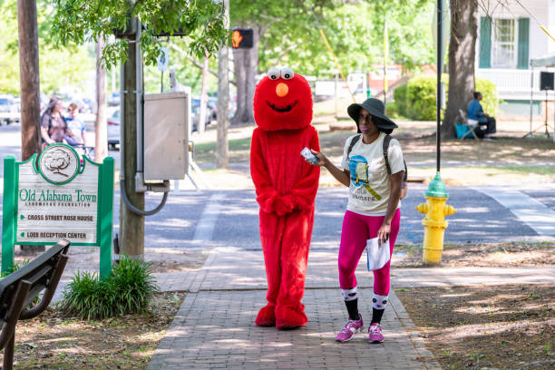 casco antiguo de alabama con festival de libros durante el fin de semana soleado y la gente caminando con traje rojo elmo - elmo fotografías e imágenes de stock