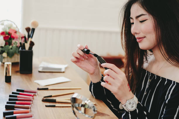 istock asian woman applying makeup cosmetic 1154223570