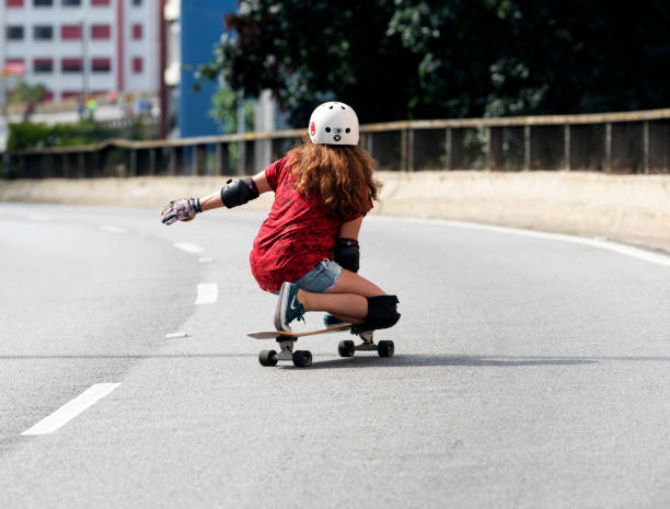 A teenager happily skateboarding in the shade