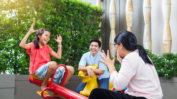 happy asian family relaxing and spending time together at playground park outdoors - love growth time of day cheerful imagens e fotografias de stock