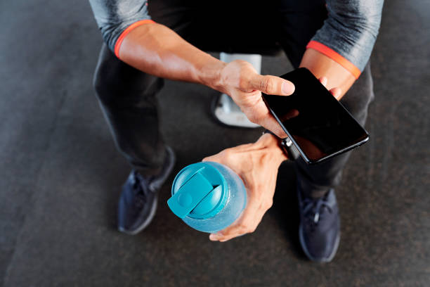 istock Active man with water bottle and smartphone 1154249219