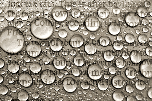 Newspaper covered with Magnifying Water Drops