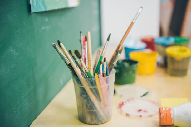istock Artistic equipment in a artist studio. Paint brushes in the plastic glass. Selective focus. 1154257693